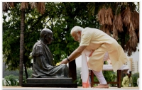 اوخود یک هندوی افراطی عضو آر.اس.اس است که در پشت پرده ترور گاندی است - نارندرا مودی نخست وزیر هند در حال اعطای گل به مجسمه گاندی در احمدآباد هند