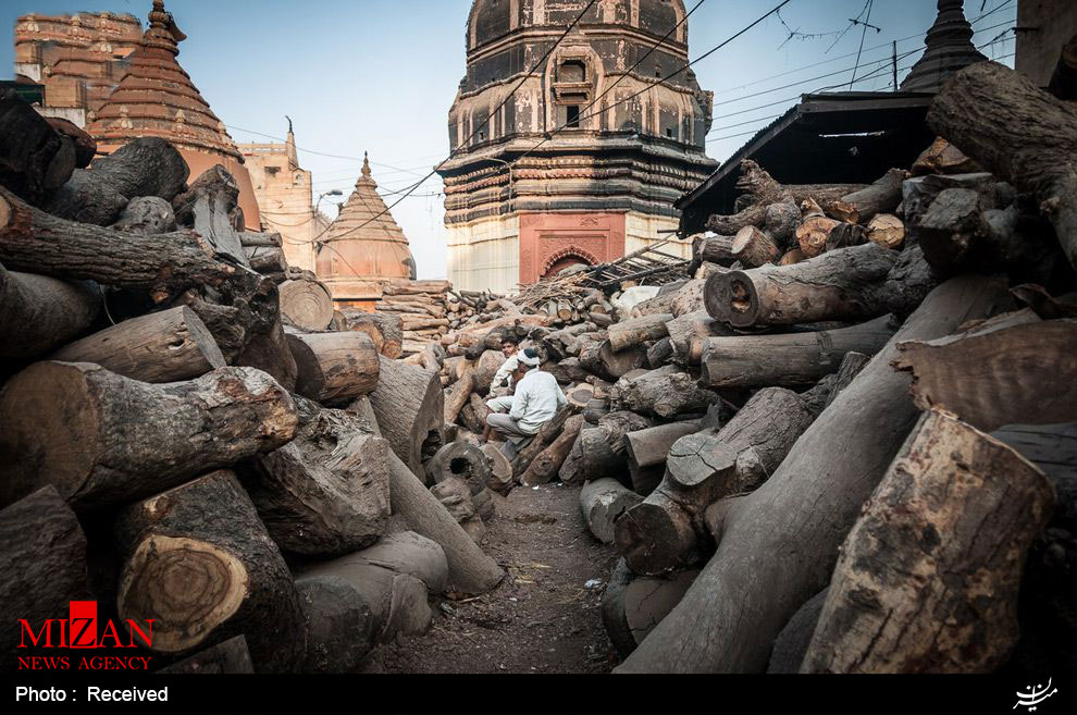  خروارها چوب در محل مرده سوزانی در کنار یک معبد هندوها در هند